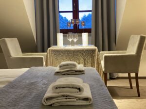 zastawiony stół, łóżko, ręczniki